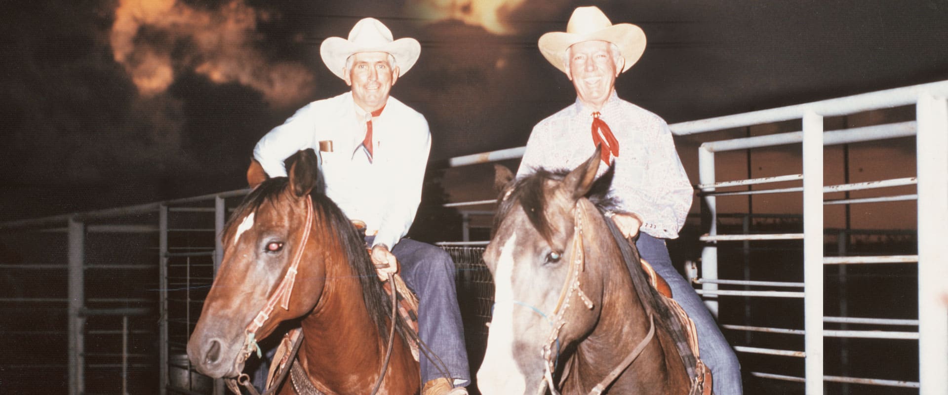 Two men in cowboy hats on horsebacks